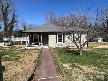 Charming single-story home with a welcoming front porch and landscaped front yard on a sunny day at 228 Hazeleen Ave, Belmont, NC 28012
