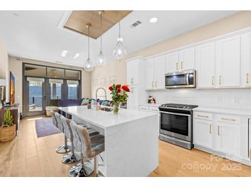 Beautiful kitchen boasts a large island with quartz countertops, stainless steel appliances, and modern pendant lighting at 2401 Euclid Ave # 306, Charlotte, NC 28203