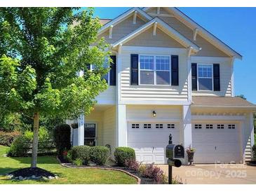 Charming two-story home with a well-manicured lawn, mature tree, and two-car garage at 249 Sand Paver Way, Fort Mill, SC 29708