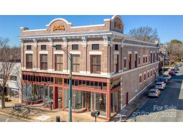 The renovated Kress building featuring retail spaces, with large windows and a red trim facade at 300 S Main St # K, Salisbury, NC 28144