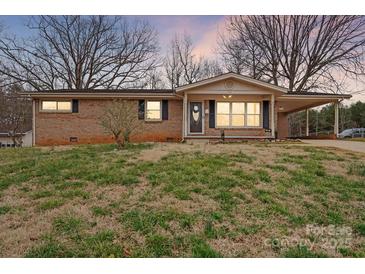 Charming brick ranch home featuring a well-manicured lawn and covered carport at 512 Rhodes Ave, Kings Mountain, NC 28086
