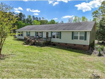 Charming single-story home featuring a spacious wooden deck, green shutters, and a well-maintained lawn at 1766 Duckwood Rd, Lancaster, SC 29720