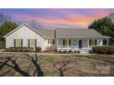 Charming home with a welcoming front porch, beautiful yard, and classic architectural details at 202 Oakwood St, Stanfield, NC 28163