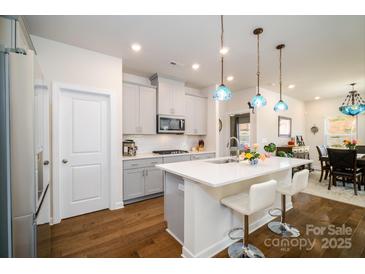 Modern kitchen featuring gray cabinets, stainless steel appliances, and a stylish island with seating at 4321 Duplin Dr, Charlotte, NC 28214