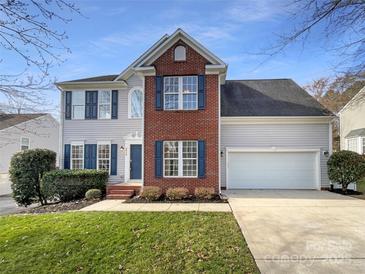Charming two-story home with a brick facade, blue shutters, attached two-car garage, and a well-maintained lawn at 4910 Summerside Dr, Clover, SC 29710