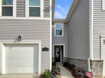 Charming townhouse showcasing a well-maintained front exterior and attached one car garage at 5629 Axil Ln, Charlotte, NC 28269
