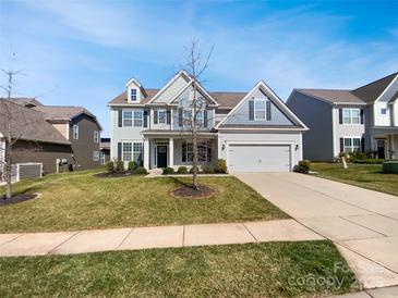 Charming two-story home with a manicured lawn and attached two-car garage at 6234 Artigas Dr, Fort Mill, SC 29707