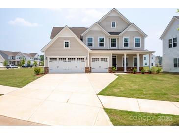 Charming two-story home featuring a three-car garage and covered front porch at 730 Autumn Sage Dr, Indian Trail, NC 28079