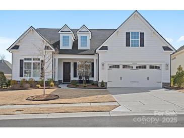 Charming white home features a manicured lawn, a two car garage and classic black window shutters at 82116 Standing Oak Dr, Charlotte, NC 28278