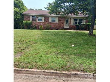 Charming brick home with a well-manicured front lawn and mature trees, offering great curb appeal at 948 Shannon Bradley Rd, Gastonia, NC 28052