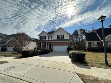 Charming two-story home with a well-manicured lawn, a two car garage and blue shutters at 1043 Boxelder Ln, Charlotte, NC 28262