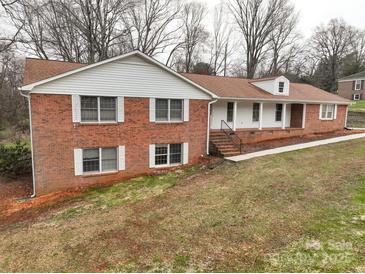 Charming red brick home with white trim, dormer, and a welcoming covered front porch at 107 S Myrtle Ave, China Grove, NC 28023