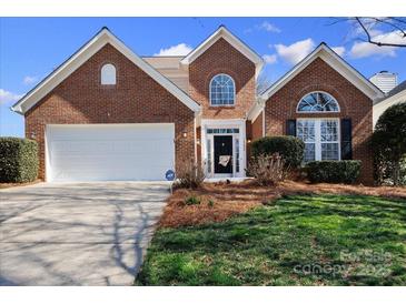 Charming brick home with a well-manicured lawn and a two-car garage offers great curb appeal at 16032 Hollingbourne Rd, Huntersville, NC 28078