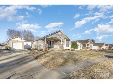 Charming single-story home featuring a covered front porch with stone accents and a well-maintained front yard at 1720 Dewberry Pl, Salisbury, NC 28146