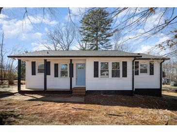 Charming home showcasing light blue front door, black shutters, and white siding under a partly cloudy sky at 523 Hickory Nut Ln, China Grove, NC 28023