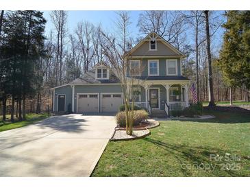 Charming two-story home featuring a welcoming front porch, well-manicured lawn and two car garage at 8509 Aspen Ct, Charlotte, NC 28227