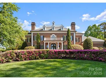 Beautiful brick home featuring a manicured front yard and a blooming hedge at 131 The Point Dr, Mooresville, NC 28117