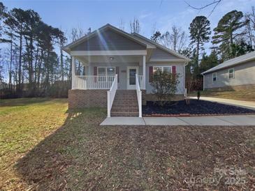 Charming single-story home featuring a welcoming front porch and landscaped front yard at 134 Burke Cir, Mooresville, NC 28115