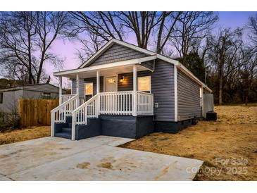 Charming home featuring gray siding, a cozy front porch, and freshly poured concrete driveway at 343 Bell St, Mooresville, NC 28115