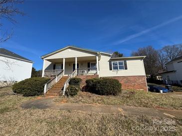 Charming single-Gathering home with a welcoming front porch and a brick foundation, surrounded by a well-maintained yard at 7201 Gilead Rd, Huntersville, NC 28078