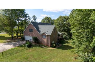 Charming brick home featuring an attached garage, spacious backyard, and a deck at 912 Silver Charm Ln, York, SC 29745
