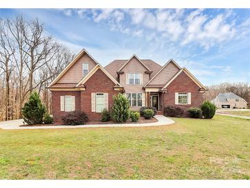 Charming brick home with a well-manicured lawn and beautiful landscaping at 1011 Duntov Dr, Monroe, NC 28110