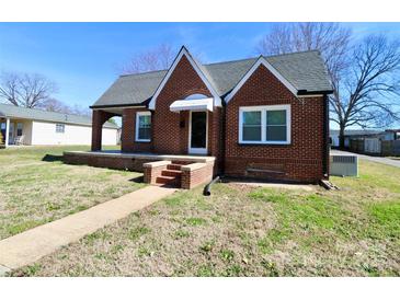 Charming brick home with a covered front porch and well-maintained lawn under a clear, blue sky at 104 N 9Th St, Bessemer City, NC 28016