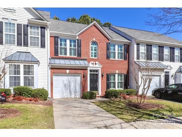 Charming brick townhouse with an attached garage, manicured landscaping, and a welcoming front door at 128 S Arcadian Way, Mooresville, NC 28117