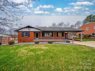 Charming brick home features a well-manicured lawn and a covered carport at 337 Glenwood Dr, Mooresville, NC 28115
