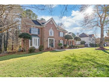 Beautiful two-story brick home with a well-manicured lawn and manicured shrubbery at 5101 Belicourt Dr, Charlotte, NC 28277