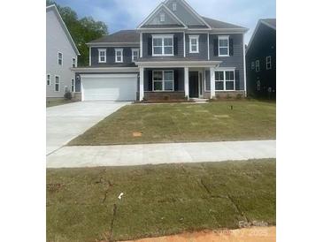 Charming two-story home featuring a wide driveway, a two-car garage, and a well-manicured lawn at 138 Nicholson Ln, Mooresville, NC 28115