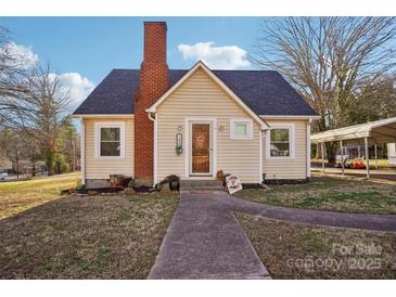 Charming cottage-style home with a brick chimney, quaint front yard, and inviting walkway at 148 Linwood Dr, Albemarle, NC 28001