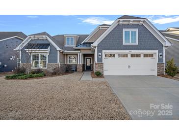 Charming home featuring a stone and siding facade, attached two-car garage, and well-manicured lawn at 1809 Tranquility Blvd, Lancaster, SC 29720