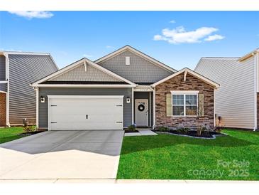 Charming one-story home featuring a two-car garage, well-maintained lawn, and a welcoming stone-accented facade at 1949 Vanderlyn St, Monroe, NC 28112