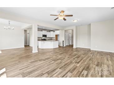 Spacious living room featuring modern wood floors and a seamless open-concept layout with access to the kitchen at 2504 Hovis Rd, Lincolnton, NC 28092