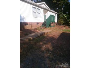 A modest home with white siding and a charming green-painted porch and steps at 630 Pinelake Dr, Troy, NC 27371