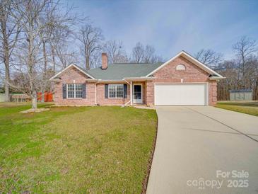 Charming brick home with a two-car garage and a well-manicured lawn, offering curb appeal and convenience at 8353 Emily Dr, Harrisburg, NC 28075