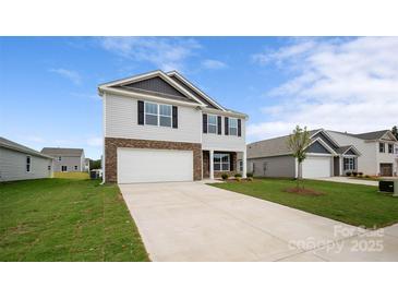 Two story home featuring stone accents, a two-car garage, and a well-manicured lawn at 1113 Foxberry Ln, Maiden, NC 28650