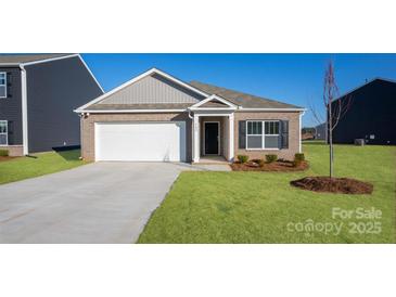 Charming brick home featuring a two-car garage, well-maintained lawn, and classic architectural details at 1129 Foxberry Ln, Maiden, NC 28650