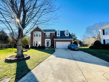 Charming two-story brick home with manicured lawn, long driveway, and attached two-car garage at 11307 Celandine Ct, Charlotte, NC 28213