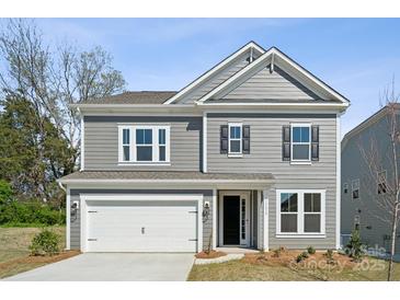 Charming two-story home with gray siding, a two-car garage, and a well-maintained front yard at 15238 Ravenall Dr, Huntersville, NC 28078