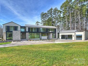 Modern home exterior with expansive lawn and a three-car garage at 2536 Brawley School Rd, Mooresville, NC 28117