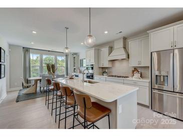 Bright kitchen featuring a large island with seating, stainless steel appliances, and ample cabinet space at 344 Catawba Ave, Davidson, NC 28036