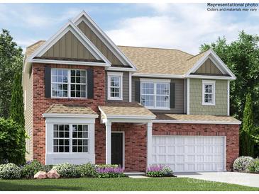 Two-story home featuring brick and siding, an attached garage and a well-manicured lawn at 4625 Potters Wheel Dr, Fort Mill, SC 29715
