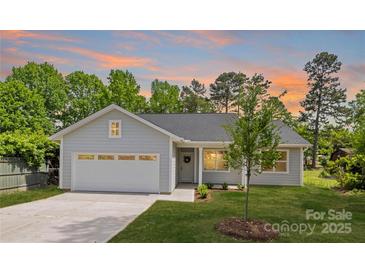 Charming single-story home features a manicured lawn, attached garage, and welcoming front porch at 5404 Maplewood Ln, Charlotte, NC 28227