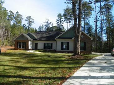 Charming single story home with brick and white siding on a spacious lot with mature trees at 128 Summerlake Dr, New London, NC 28127