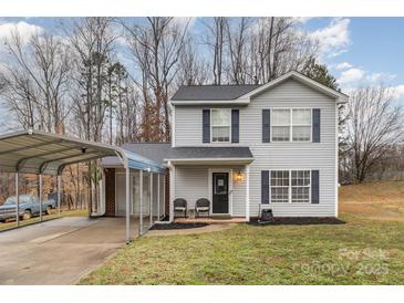 Well-kept two-story home with carport, manicured lawn, and charming details at 2444 Fabyan Ln, Charlotte, NC 28262