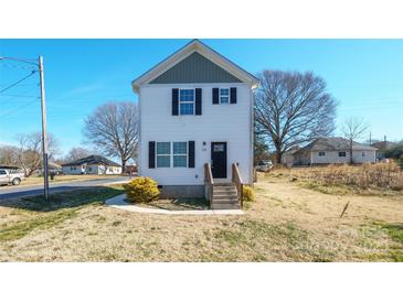 Two-story home with light siding, black shutters, simple landscaping and a small porch entry at 418 N Pear St, Gastonia, NC 28054