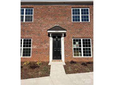 Charming brick home featuring a black front door with a classic awning and white trim at 435 Beacon Nw St, Concord, NC 28027