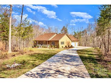 Beautiful brick home with a long driveway and well-manicured lawn surrounded by mature trees at 809 Liberty Rd, Gold Hill, NC 28071